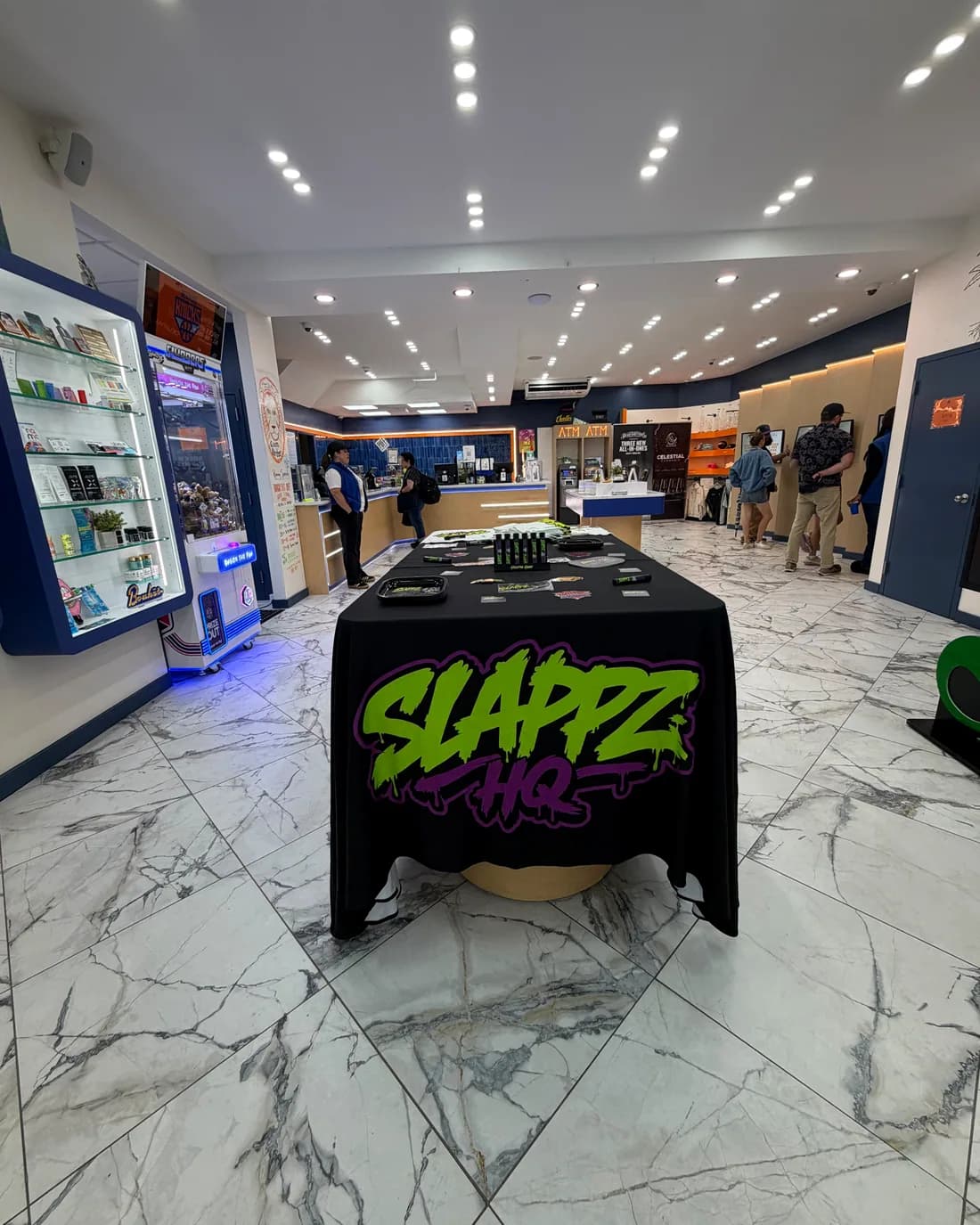 A SLAPPZ HQ branded table set up on the sales floor of a licensed dispensary.
